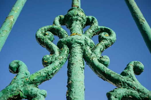 Green weathered iron door full of yellow lichens. Closeup