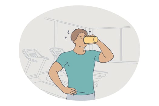 Professional sport, workout, training concept. Young man athlete standing and drinking water after training in gym and feeling energetic. Active lifestyle, fitness, bodycare, wellness