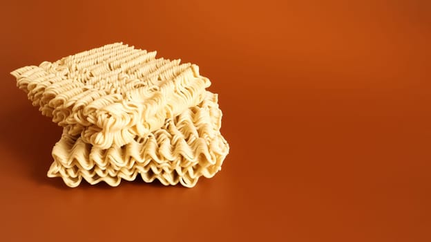 Raw dried instant noodles on a brown background. pasta, for the preparation of which it is enough to pour boiling water and wait a few minutes. Copy space. Vermicelli, spaghetti