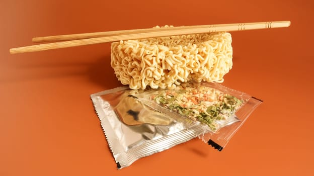 Raw instant noodles with chopsticks and spices. Copy space asian food. pasta, for the preparation of which it is enough to pour boiling water and wait a few minutes. flavored spaghetti