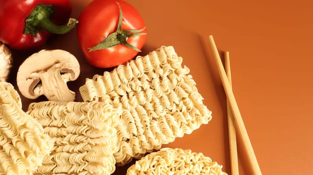 Instant noodles with king mushrooms, seasonings, soy sauce, peppers, green onions, tomatoes. Vegetable fast vegetarian soup. The process of cooking Asian food on the table. Vermicelli, spaghetti.