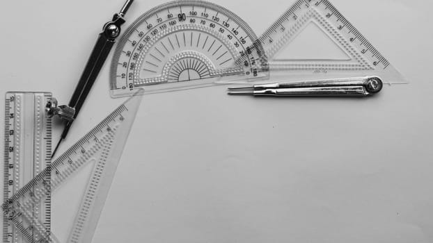 Geometric Measuring tools, Drawing items and mathematical instruments placed on white paper sheet. Back to school and Engineering education learning background. Empty Copy space room for text.