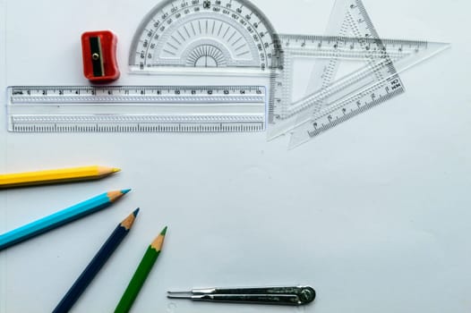 Geometric Measuring tools, Drawing items and mathematical instruments placed on white paper sheet. Back to school and Engineering education learning background. Empty Copy space room for text.