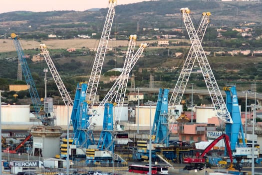 Civitavecchia. Italy - February 17, 2025: Several cranes in operation at the bustling port of Civitavecchia, Italy It captures the vibrant industrial activity and the essential role of heavy machinery