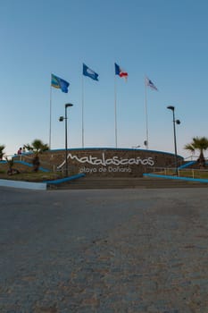 Donana Beach roundabout flags in Matalascanas. Costa de la Luz seashore, Huelva, Spain