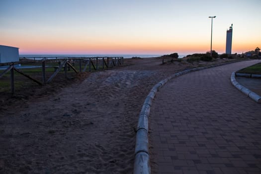 Costa de la Luz promenade all along the lighthouse at dusk, Almonte, Huelva, Spain