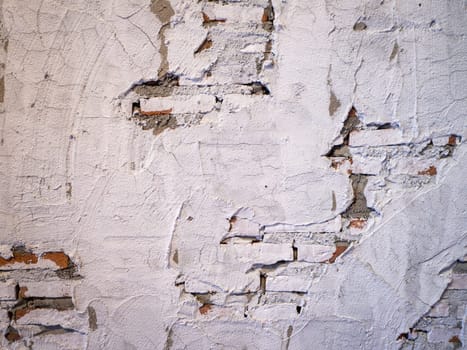 Old brick wall with peeling plaster, grunge background