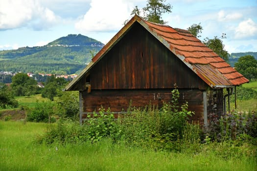 old barn with a hill in the background