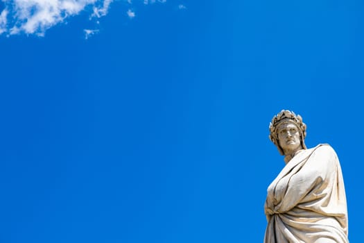 Dante Alighieri statue in Florence, Tuscany region, Italy, with an amazing blue sky background.