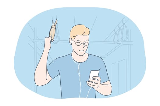 Online communication in transport concept. Smiling teen boy standing in subway or bus with smartphone, chatting, listening to music or watching movie online in earphones and looking at screen