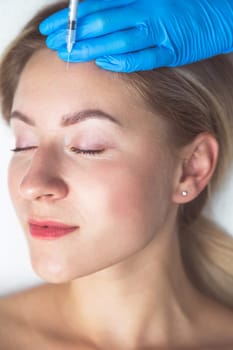 Rejuvenating facial injections procedure for tightening and smoothing wrinkles on the face skin of a beautiful, young woman in a beauty salon.Cosmetology skin care.