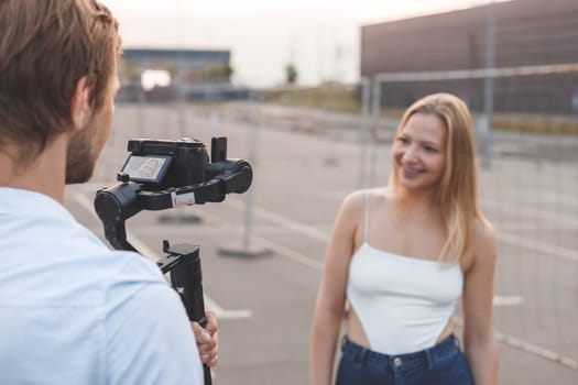 Cameraman is filming the blogger's girl on the street.
