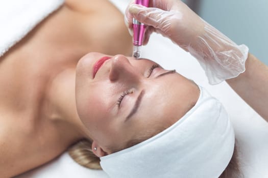 Woman having facial treatment in beauty salon, closeup. Oxy derma therapy with derma pen