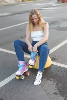 Hipster woman putting on inline skates outdoors. Close up. Sport lifestyle.