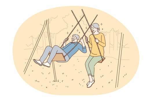 Senior elderly couple living happy active lifestyle concept. Happy mature loving couple pensioners woman and man riding on swing and having fun like children outdoors. Retiree, pensioner happiness