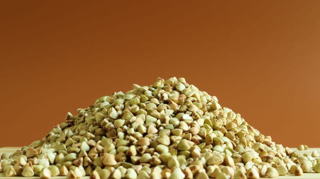 Green buckwheat seeds on a wooden background. Great food. healthy groats. Organic raw non-fried vegetarian food. The concept of a healthy, balanced and dietary diet. Copy space