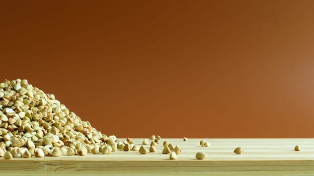 Green buckwheat seeds on a wooden background. Great food. healthy groats. Organic raw non-fried vegetarian food. The concept of a healthy, balanced and dietary diet. Copy space
