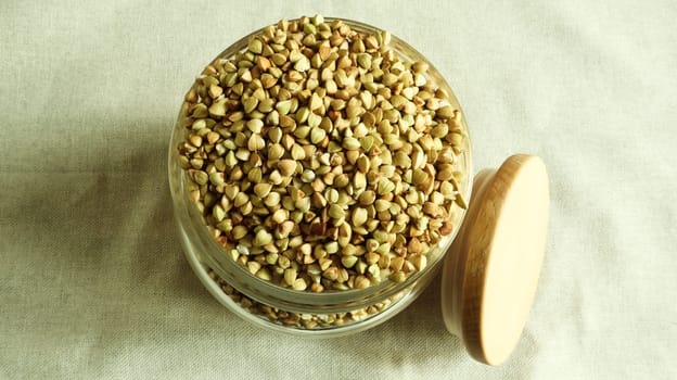 Green sprouts of raw organic buckwheat in a glass cereal jar with a wooden spoon. Vegan food concept. Organic food. The concept of diet, weight loss, healthy and proper nutrition. top view, flat lay.