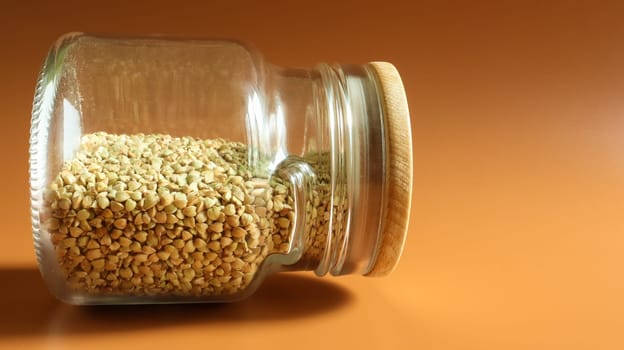 Green sprouts of raw organic buckwheat in a glass jar for cereals. Vegan food concept. Organic food. The concept of diet, weight loss, healthy and proper nutrition. Copy space for text
