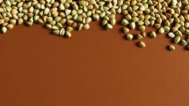 Background from raw organic green buckwheat porridge, vegan food. Texture of scattered buckwheat groats. Seeds are triangular in shape. Organic food. The concept of diet, weight loss, healthy eating