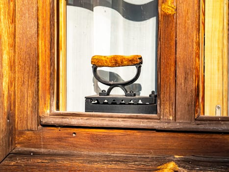 Antique charcoal iron for ironing clothes on a window sill. Retro technology. Tool. Background image. Place for text.
