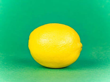 Yellow lemon on a green background. Fruit. Food photo. Place for text. Showcase.
