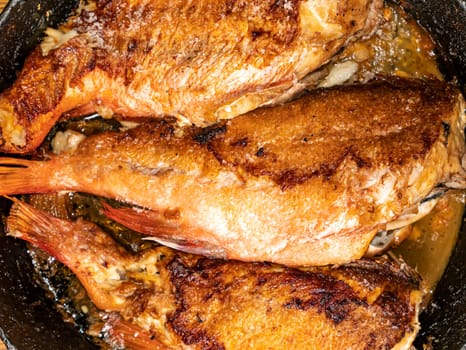 Fried fish sea bass in a pan. Food photo. Menu. Place for text. Kitchen.