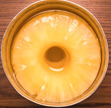 Sliced pineapple in a tin can with juice. Food photo. Place for text.