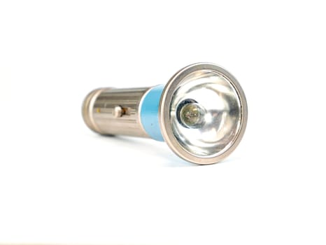 Pocket flashlight in a metal case on a white background. Retro. Technology. Place for text. Background image.