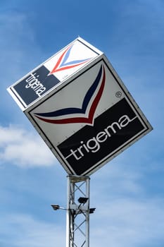 KIRCHHEIM, GERMANY -2019-07-10: TRIGEMA Logo Advertisement. TRIGEMA was established in 1919 and is Germany’s largest manufacturer of sportswear and casual fashion.