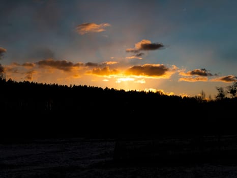 Sunset in the clouds over the forest horizon. Nature. Scenery. Background image.