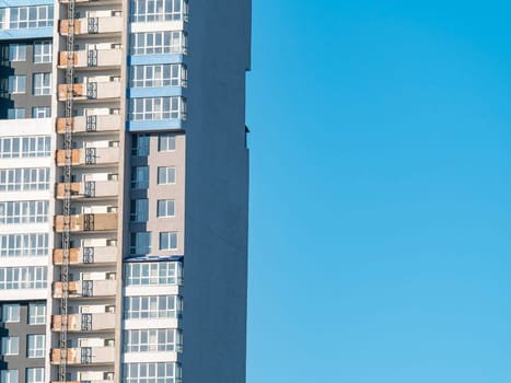 The wall of a high-rise building against the blue sky. Background image. Place for text.
