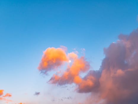 Cloudy landscape with the moon in the rays of a sunny sunset. Nature. Scenery. Background image. The head of a dragon.