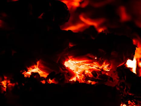 Red heat of charcoal burning wood in the dark. Fire. Background image. Place for text.