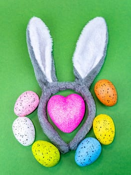 Colored easter eggs with bunny ears and heart. Holiday. Religion. The culture. Place for text. Background image. Template. The symbol of the heart.