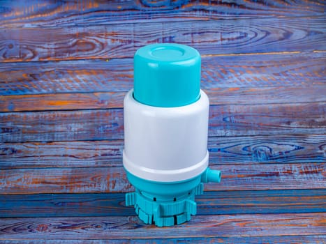 Pump for a bottle of water on the table. Place for text. Background image. Technology.