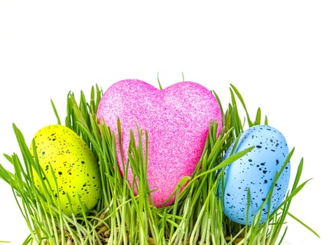 Colored easter egg and heart in green grass on a white background. Easter. Religion. The culture. Place for text. Background image.