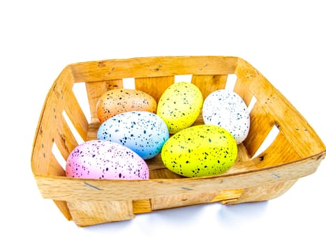 Easter eggs in a wooden basket of hearts on a white background. Place for text. Template. Background image. Religious holiday. The culture.