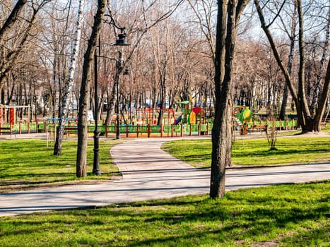 Playground in a spring public park in the sun. Background image. Place for text. Infrastructure.