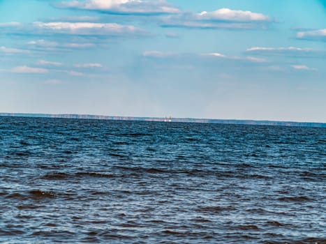Water horizon against a blue cloudy sky. Natural background. A place for fishing. Background image. Place for text. Landscape. Sunny day. Blue sky.