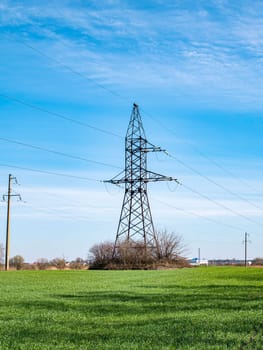 The tower of a high-voltage line of electric power transmission on a background of blue sky. Technology. Electrical equipment. Sky horizon Background image. Place for text.
