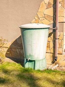 Large plastic water tank with tap in the garden. Garden tools. Garden equipment. Background image. Place for text.