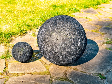 Balls of thread on a green flowerbed of a public park. Decor flower beds. Background image. Place for text. Hand mei. Handwork. Decoration.