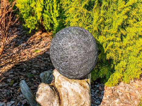 Balls of thread on a green flowerbed of a public park. Decor flower beds. Background image. Place for text. Hand mei. Handwork. Decoration.