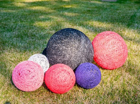 Colored balls of wound thread on a grassy lawn. Design. Background image. Place for text. Interior.