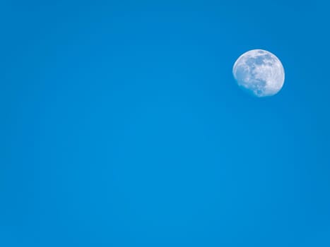 The moon against the evening blue sky. Space. Satellite of the planet earth. Place for text. Background image.