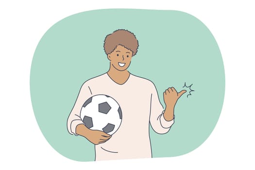 Professional football player, soccer ball, sport concept. Young smiling man football player standing with soccer ball and pointing aside on field during workout. Sport, athletics, team sport vector