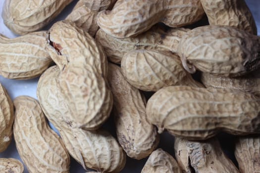 Unpeeled peanut with shells. Food background of peanuts