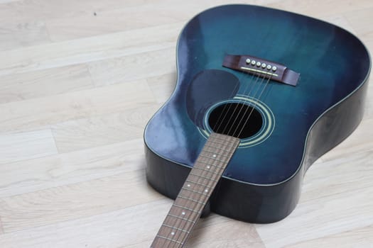 Close up of music guitar. Acoustic guitar with strings on a wooden floor