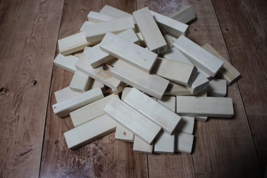 Pile of wooden blocks with engraved letters dispersed on floor. Children toy for building creative works.